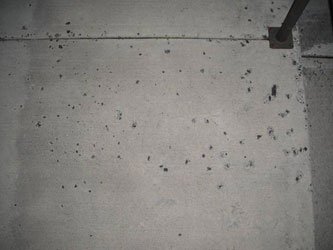 Pitting and surface pop-outs in concrete caused by salt and freeze-thaw damage
