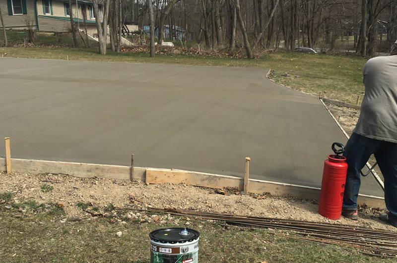 New concrete driveway being sealed after pouring in Fremont, Indiana