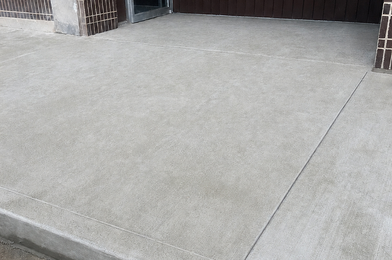 Light broom-finish concrete at a renovated commercial storefront entrance in Niles Michigan