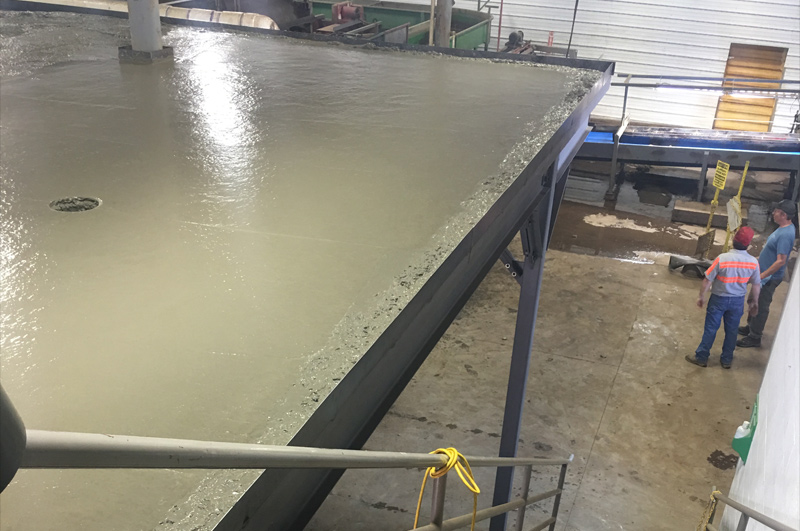 Lightweight concrete being placed and distributed across the elevated commercial floor
