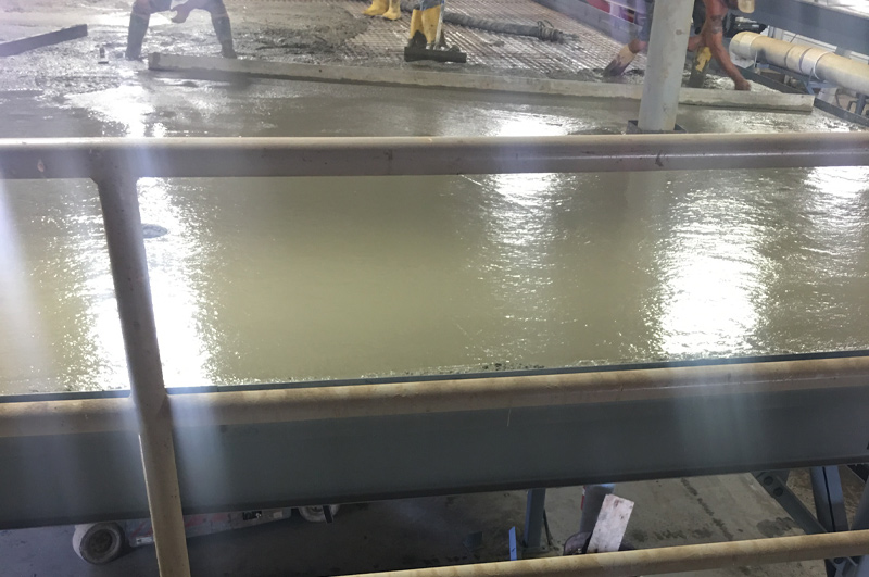 Marc Todd Concrete crew leveling freshly pumped lightweight concrete on the second story