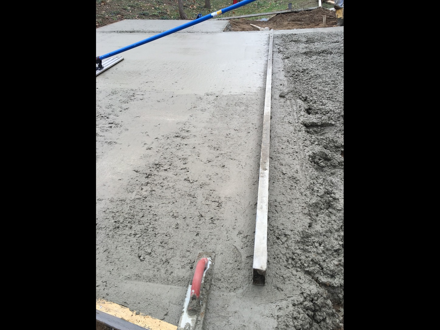 Finishing concrete driveway with curved curb edges at Klinger Lake