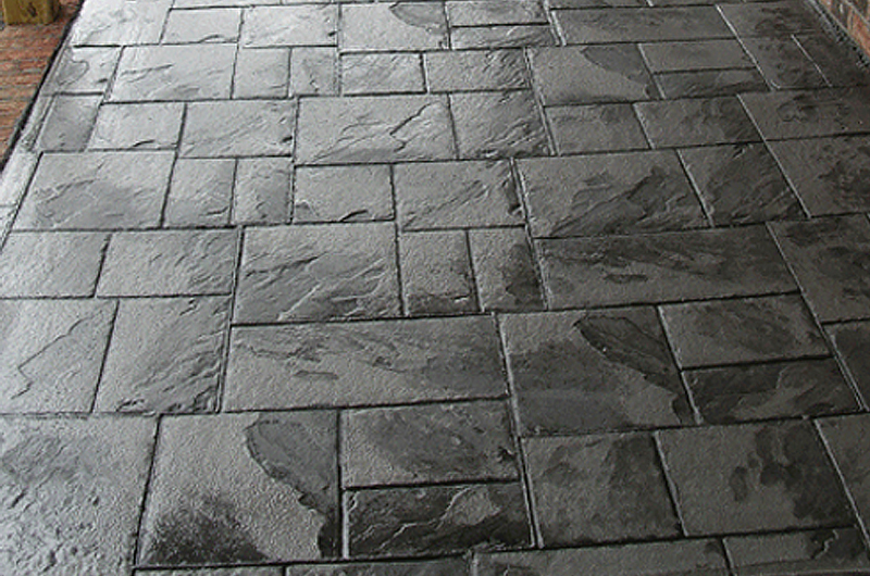 Close view of a curved colored stamped concrete sidewalk in Brighton, Indiana